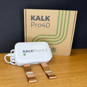 KalkPro 4.0 industrienhet - elektronisk kalkdelare med kopparband för att förhindra kalkavlagringar, framför förpackningen på ett träbord